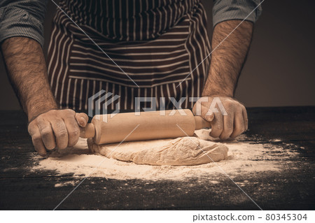 Male hands knead the dough. 80345304