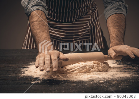 Male hands knead the dough. 80345308