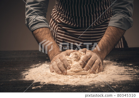 Male hands knead the dough. Male hands knead the dough. 80345310