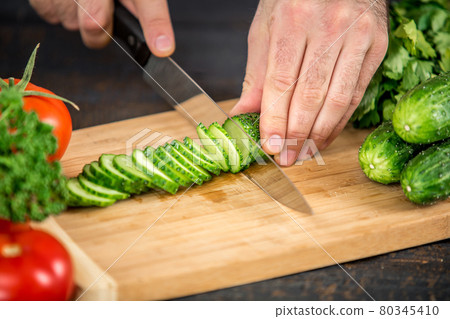 Male hands cutting vegetables for salad 80345410