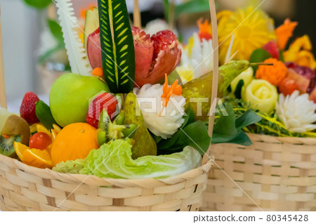 Close up: colorful fruits and flowers bouquet in wicker basket on table Close up: colorful fruits and flowers bouquet in wicker basket on table 80345428