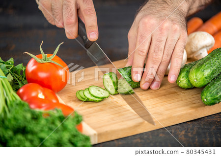 Male hands cutting vegetables for salad 80345431