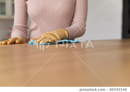 Close up young woman cleaning wooden table in gloves. Close up young woman cleaning wooden table in gloves. 80345548