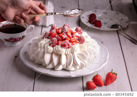 Red fruit pavlova with a cup of tea 80345892