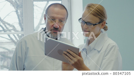 Two doctors having professional talk using touch pad Two doctors having professional talk using touch pad 80347105