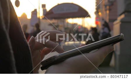 In Saint-Petersburg, Russia on evening street a girl working on mobile phone In Saint-Petersburg, Russia on evening street a girl working on mobile phone 80347117