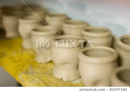 Unfinished mugs on shelf of pottery workshop - close up Unfinished mugs on shelf of pottery workshop - close up 80347380