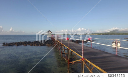 Aerial view of coast line of Mauritius Island, water laves, camera moves along pear in sea against sky Aerial view of coast line of Mauritius Island, water laves, camera moves along pear in sea against sky 80348253