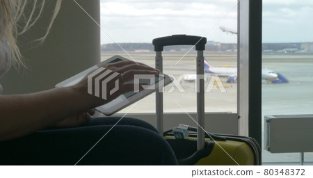 Woman waiting for the flight with tablet PC Woman waiting for the flight with tablet PC 80348372