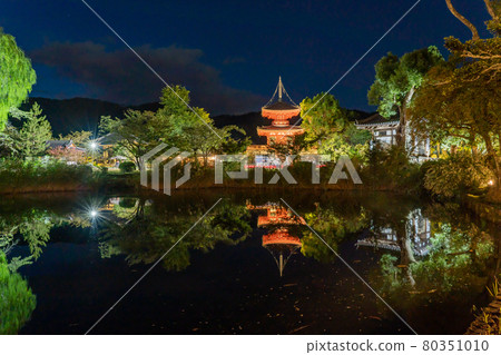 The vermilion Shingyo-Hoto pagoda that can be seen over the Hosei Pond on the evening of the moon viewing at Daikakuji Temple in Kyoto City, Kyoto Prefecture. 80351010