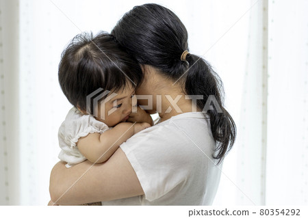 媽媽擁抱的脾氣暴躁的嬰兒(1 歲,女孩,日本人) 媽媽擁抱的脾氣暴躁的嬰兒(1 歲,女孩,日本人) 80354292
