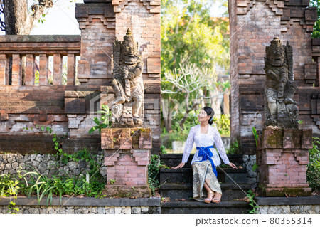A woman in a traditional costume (Kebaya) at a traditional temple in Bali 80355314