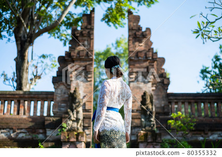 在巴厘島的一座傳統寺廟裡，一位身著傳統服飾 (Kebaya) 的女人 80355332
