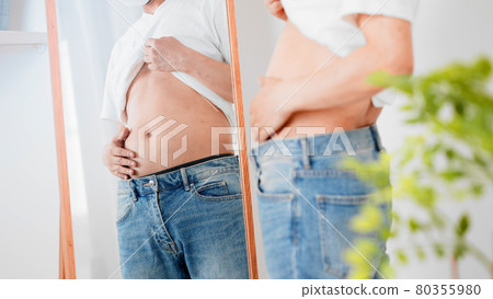 一個男人觸摸他的腹部脂肪的飲食形象 一個男人觸摸他的腹部脂肪的飲食形象 80355980