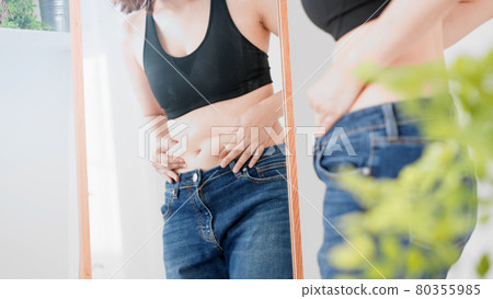 一個女人觸摸腹部脂肪的飲食形象 80355985