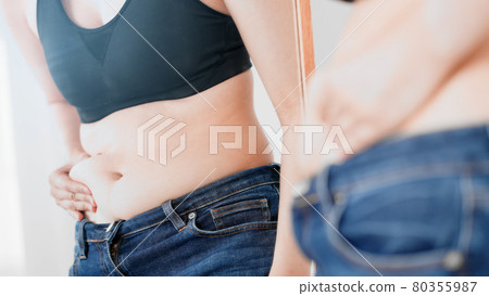 Woman touching her belly fat, diet image Woman touching her belly fat, diet image 80355987