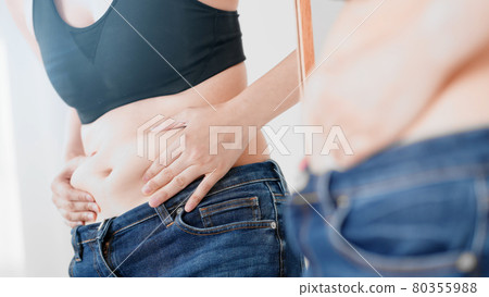 Woman touching her belly fat, diet image Woman touching her belly fat, diet image 80355988