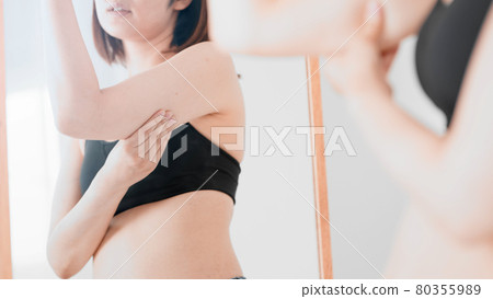 Woman touching her sagging upper arms Diet image Woman touching her sagging upper arms Diet image 80355989