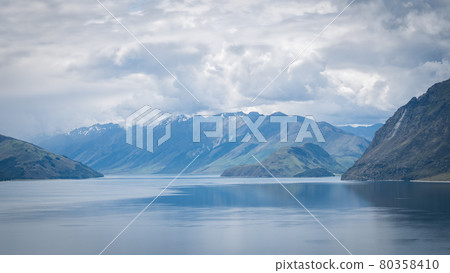 Scenic alpine lake surrounded by mountains shot on sunny day. Location is lake Hawea, New Zealand Scenic alpine lake surrounded by mountains shot on sunny day. Location is lake Hawea, New Zealand 80358410