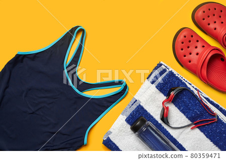 Flat lay summer pool accessories on a yellow background. Colorful beach wear. Flat lay summer pool accessories on a yellow background. Colorful beach wear. 80359471