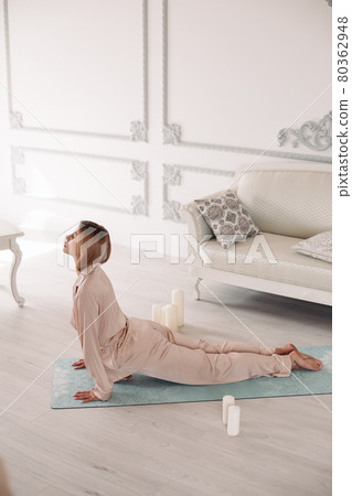 Young lady starting morning with yoga exercises in 80362948
