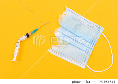 Broken Medical Syringe and Torn Medical Face Mask 80363734