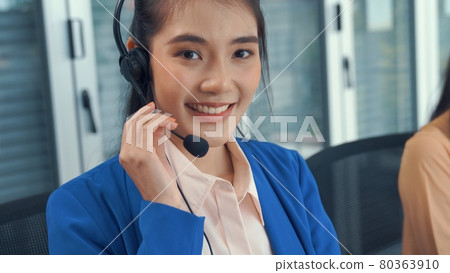 Businesswoman wearing headset working actively in office 80363910