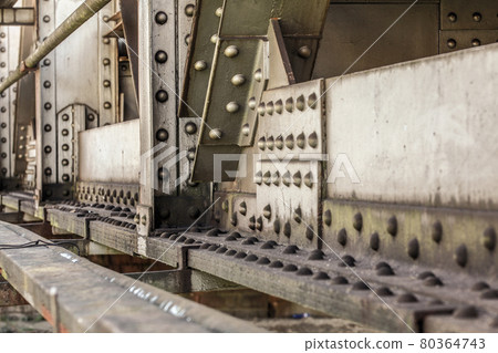 Detail of old rail bridge, large nuts, bolts and rivets visible. Abstract industrial background. 80364743