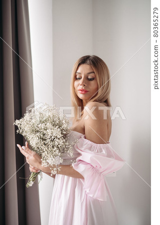 Pretty smiling young woman standing with a bouquet 80365279