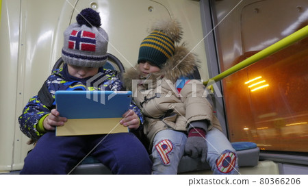 Timelapse of two boys with tablet computer in trolleybus 80366206