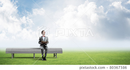 Young businessman or student studying the science in summer park Young businessman or student studying the science in summer park 80367386
