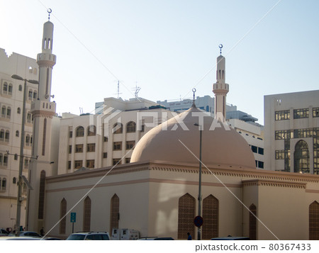 Abu Dhabi mosque with a tower and dome surrounded by buildings Abu Dhabi mosque with a tower and dome surrounded by buildings 80367433