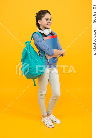Modern student girl with backpack and school supplies yellow background, knowledge day concept 80368403