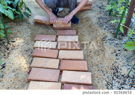 DIY laying bricks in the garden to make a small diameter DIY laying bricks in the garden to make a small diameter 80368658