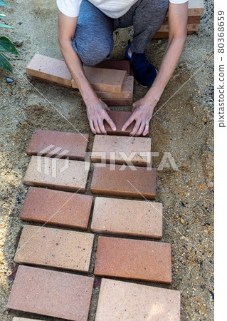 DIY laying bricks in the garden to make a small diameter DIY laying bricks in the garden to make a small diameter 80368659