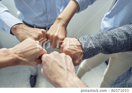 Celebrating success. Close up shot of business people doing fists bump, while standing in the office 80371033
