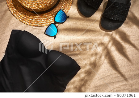 Women's beach accessories or summer outfit on sand background. Top view with copy space 80371061