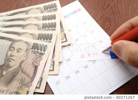 Sticky notes and calendar with repayment plan 80371267