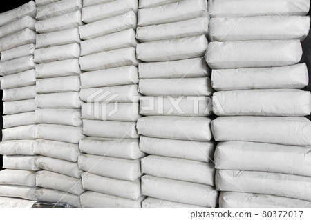 Pile of white plastic sacks in warehouse 80372017