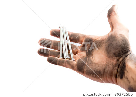 The nail in the hand stained black dust on a white background. The nail in the hand stained black dust on a white background. 80372590