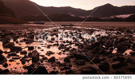 Crimson sunset in tropical inlet bay with deserted boat in frame. Landscape shot made in Abel Tasman National Park, New Zealand Crimson sunset in tropical inlet bay with deserted boat in frame. Landscape shot made in Abel Tasman National Park, New Zealand 80375695