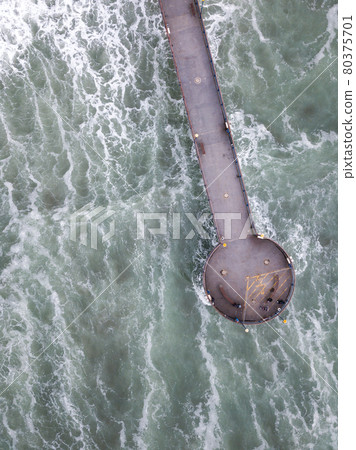 Pier in the middle of rough ocean shot from bird eye perspective. Aerial shot made in Christchurch, New Zealand 80375701