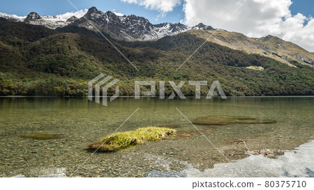 Crystal clear lake with forest and mountains in backdrop, shot at Mavora Lakes, New Zealand Crystal clear lake with forest and mountains in backdrop, shot at Mavora Lakes, New Zealand 80375710
