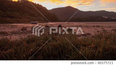 Red sunset landscape scenery in tropical inlet bay with deserted boat in frame. Shot made in Abel Tasman National Park, New Zealand Red sunset landscape scenery in tropical inlet bay with deserted boat in frame. Shot made in Abel Tasman National Park, New Zealand 80375721