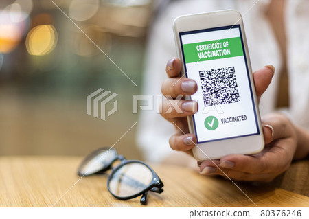Travel female hands holding smartphone with electronic certificate of vaccination at screen Travel female hands holding smartphone with electronic certificate of vaccination at screen 80376246