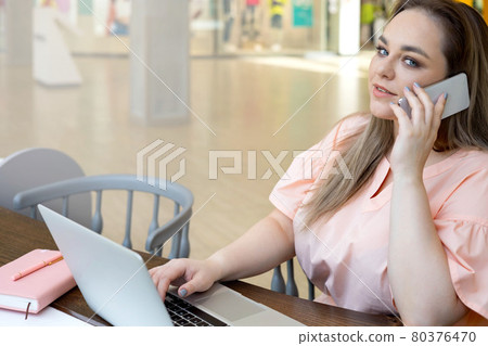 Adorable young plus size business female talking use smartphone at modern office building 80376470
