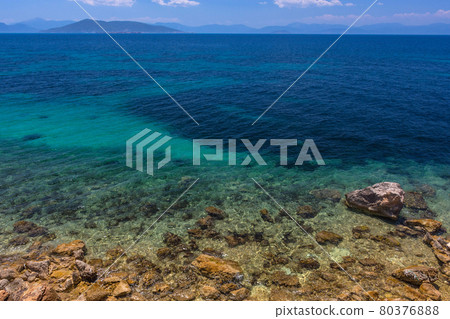 The wild coast of Aegina island with clear and blue waters of Mediterranean sea in the Saronic gulf, Greece. 80376888
