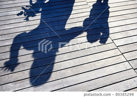A happy family's shadow reflected on a wooden deck 80385299