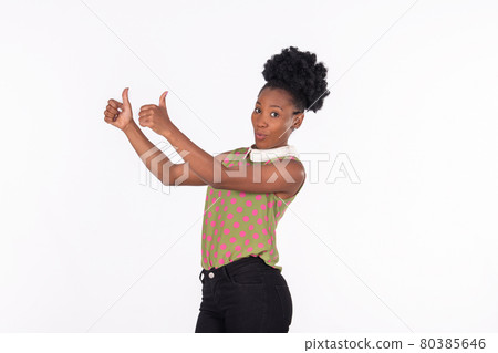 Mischievous latina woman doing a thumbs up gesture with raised hands 80385646