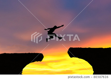 Men jump cliff sun light over silhouette concept Men jump cliff sun light over silhouette concept 80387616